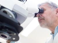 En forsker kigger i mikroskop